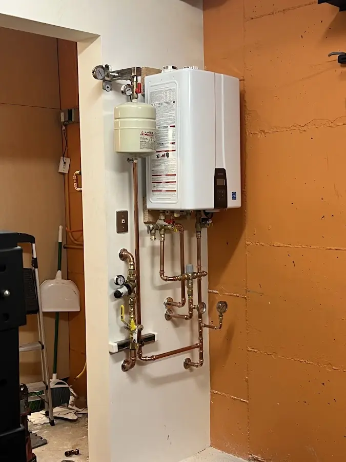 Plumbing technician inspecting water heater connections in Brawley